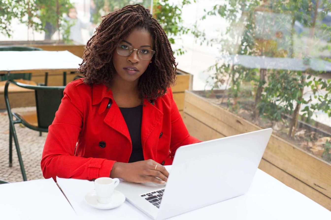 serious-woman-in front of a laptop-looking at the camera
