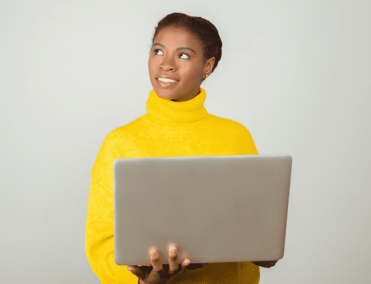 Smiling black woman holding a laptop while learning lingala language